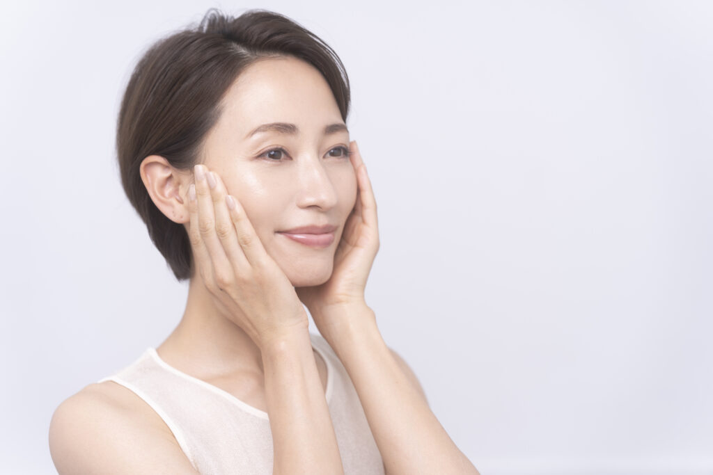 Skin care. An asian woman with beauty face is  touching healthy facial skin.